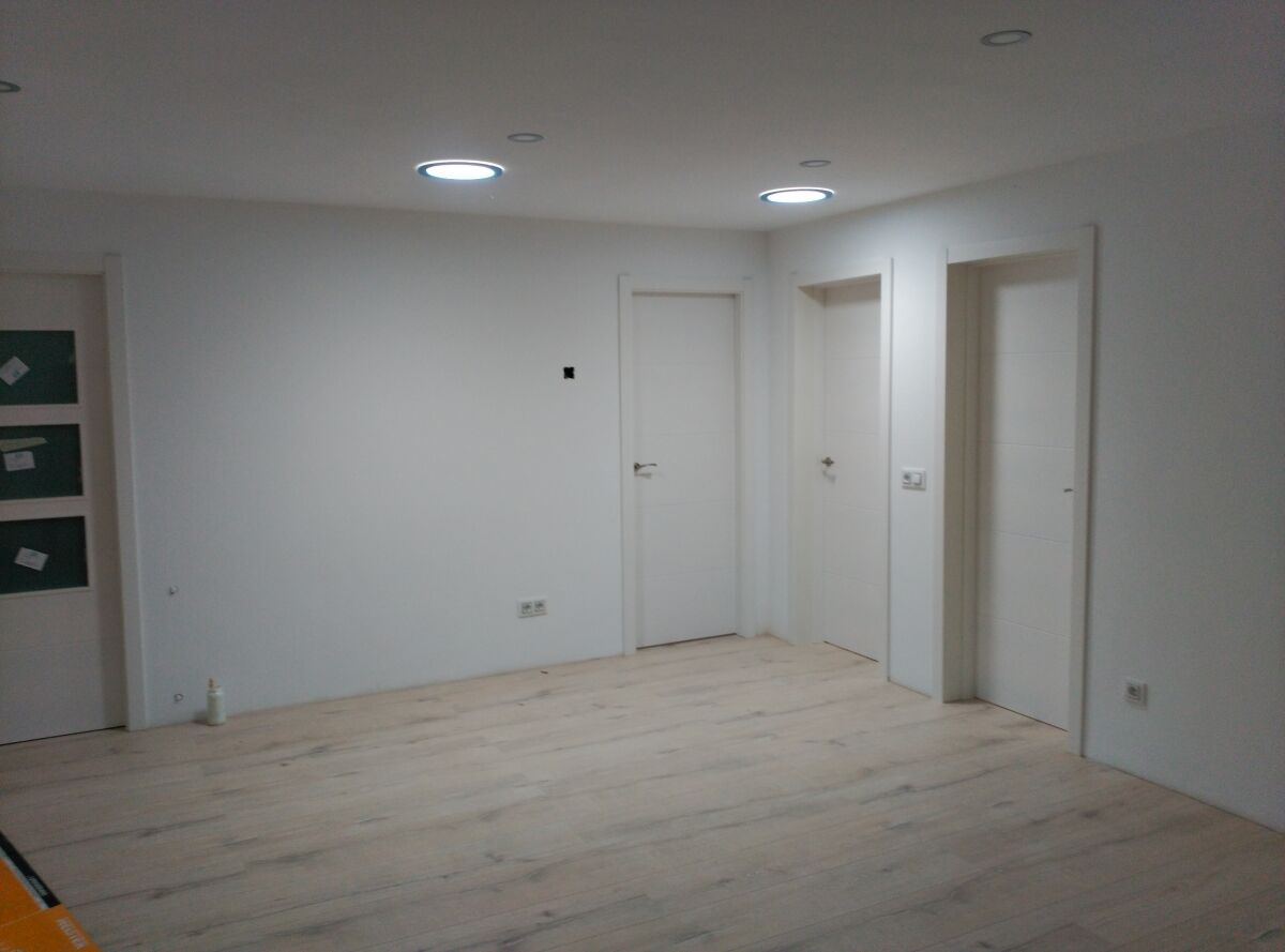 Estancia terminada con suelo continuo y puertas lacadas en blanco