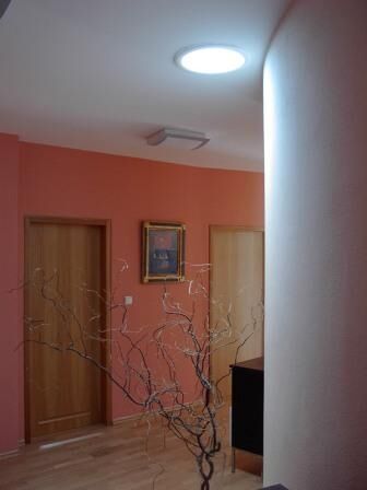 Pasillo con pared en tono rojo y luminaria circular