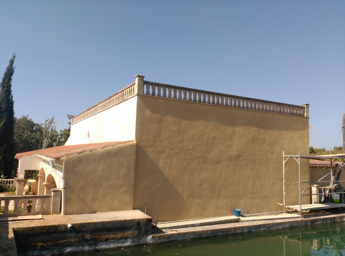 Vivienda revestida en mortero monocapa con piscina en primer término