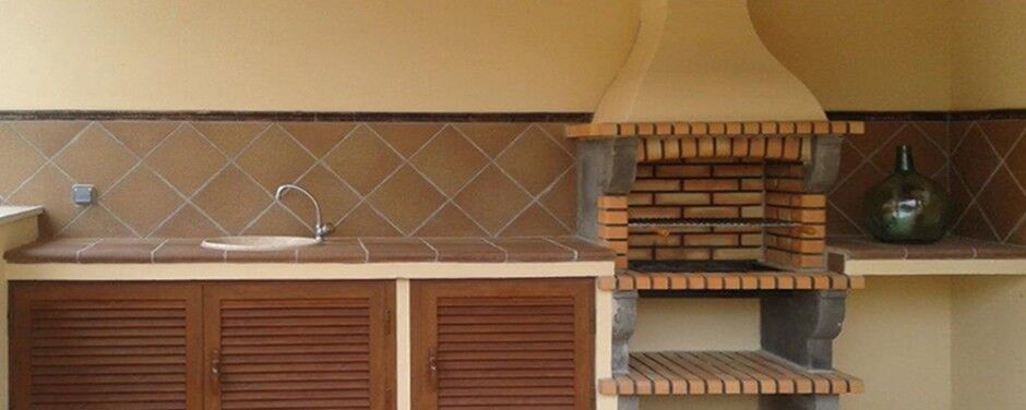 Barbacoa de obra con encimera y armarios de madera