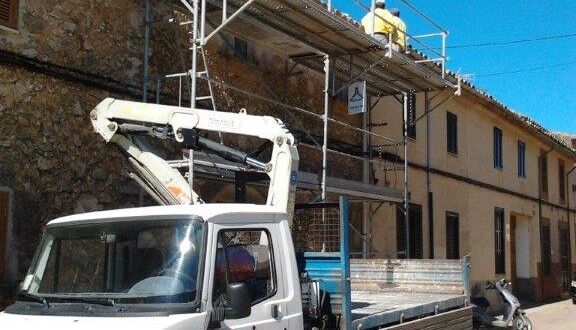 Camión grúa trabajando en la fachada de un edificio