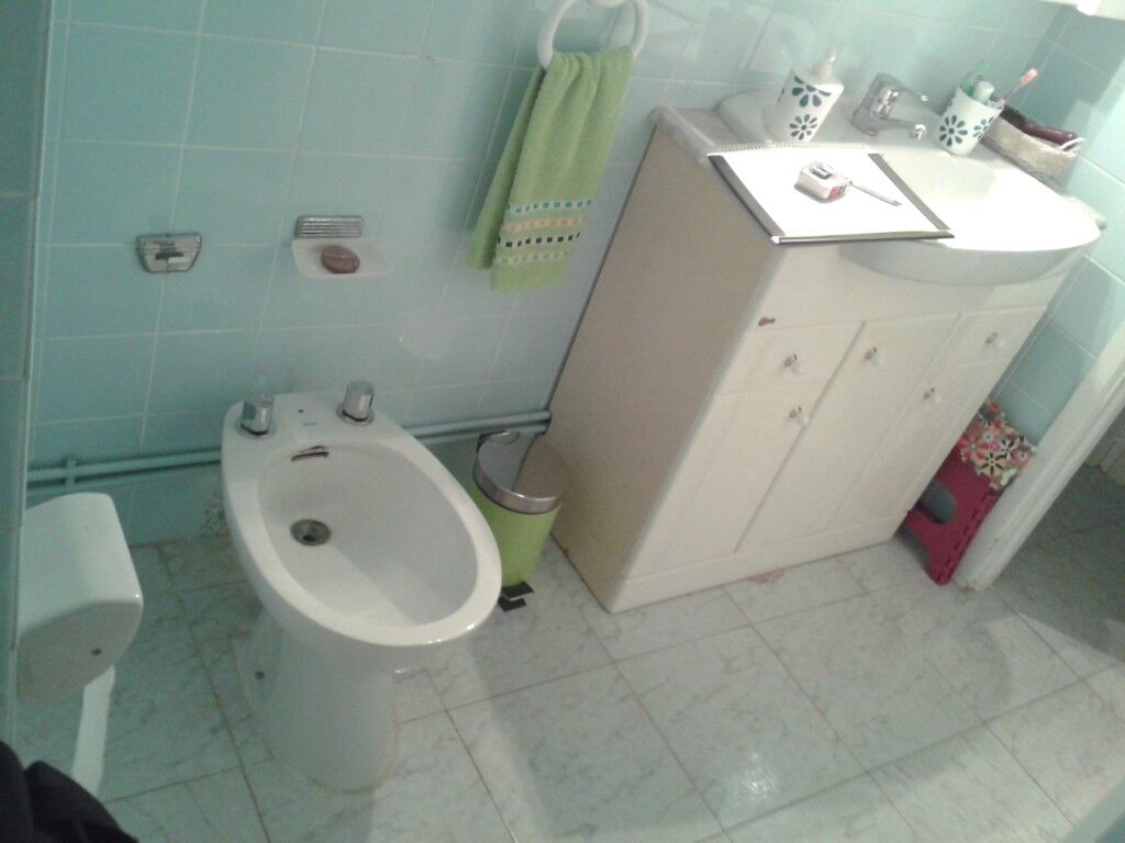 Baño terminado con lavabo, bidé y mueble bajo blanco