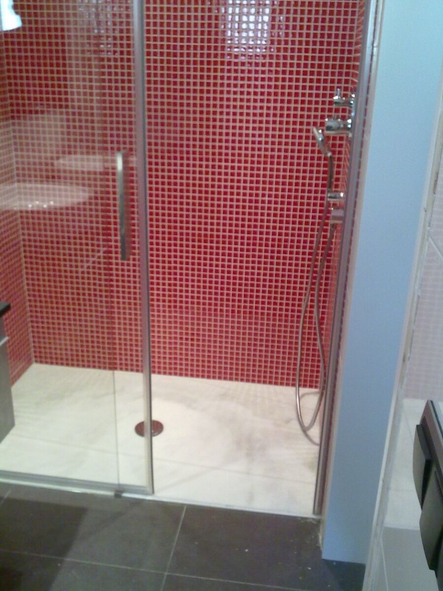 Ducha con alicatado de gresite rojo y mampara de vidrio